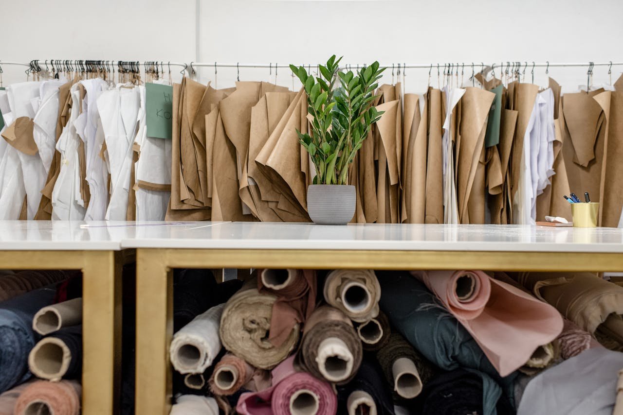 Rolls of assorted fabrics and textiles and sewing patterns inside tailor atelier